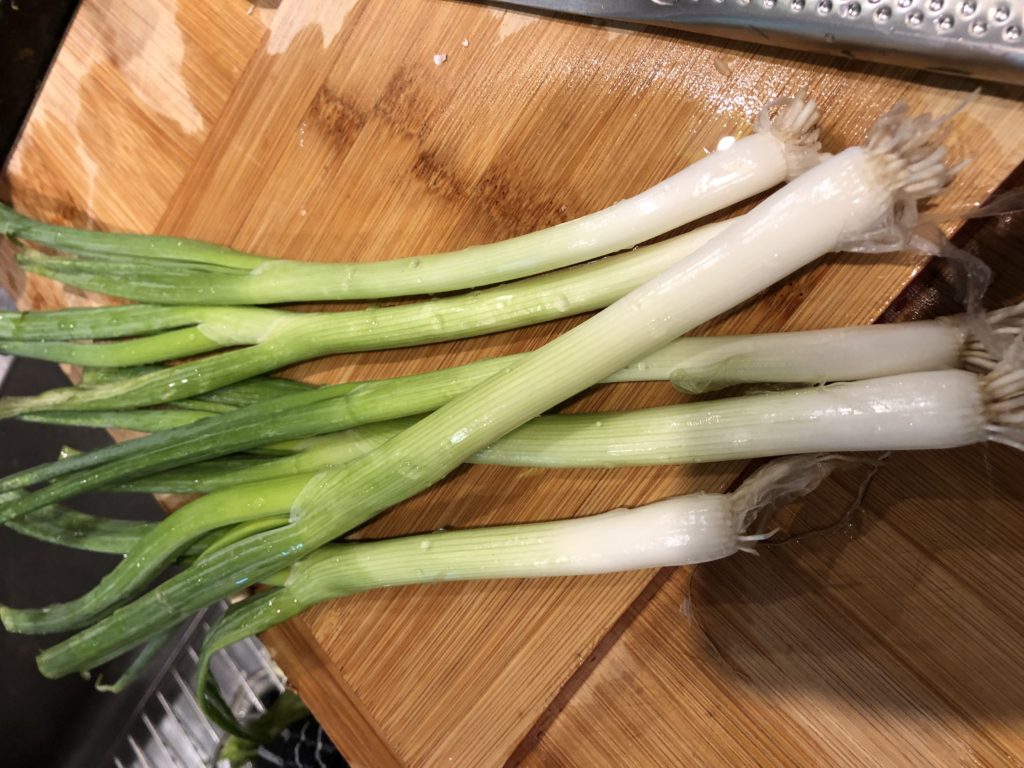 Fresh scallions (green onions) on cutting board